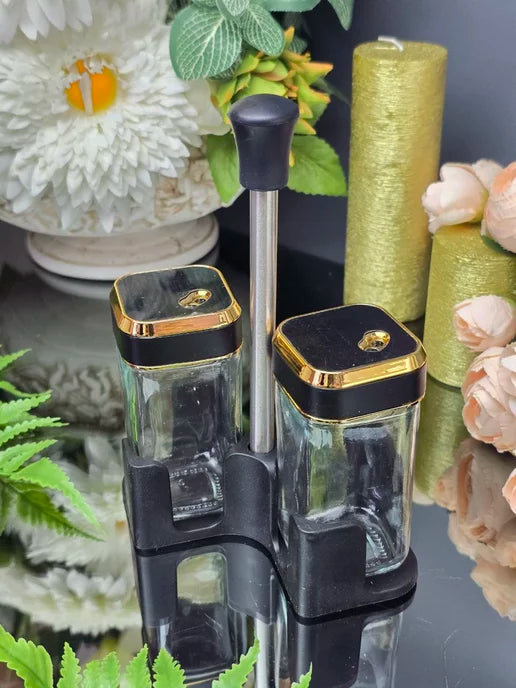 Clear container with black and gold lid on a decorative background with flowers and ribbons.